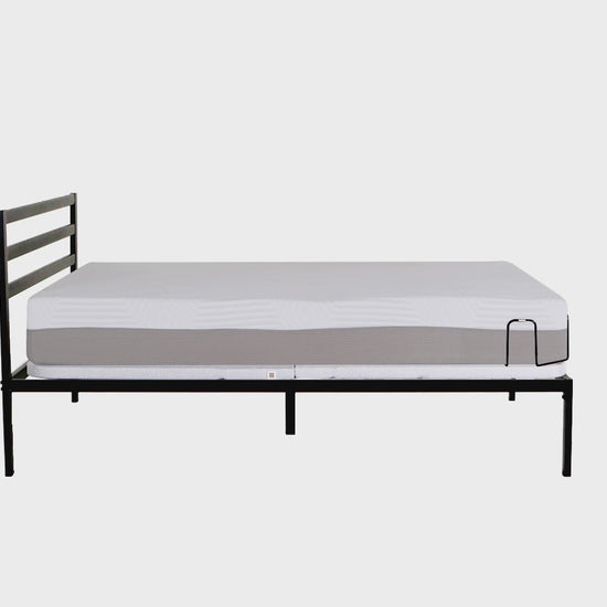 Black metal bed frame with slatted headboard supporting a white mattress, minimalistic design for modern bedroom decor